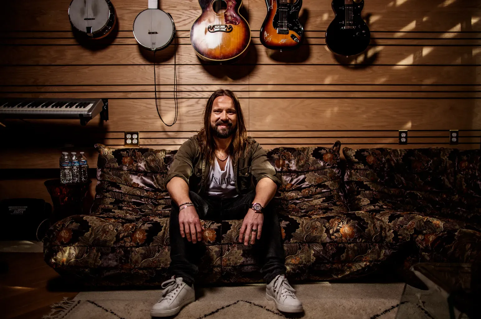 Max Martin in wide shot with guitar wall in background